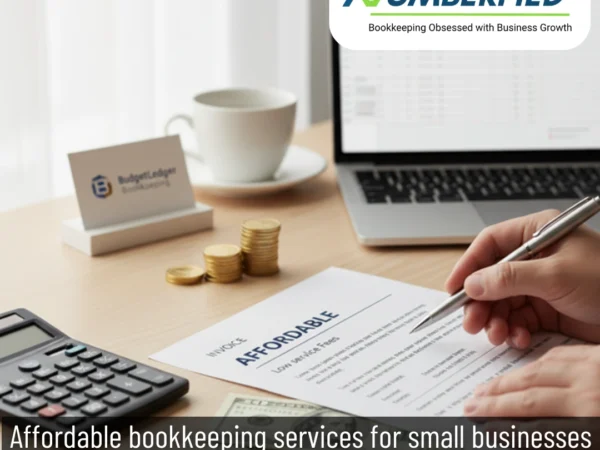 calculator, laptop and cup on table, pen in hand of a professional writing on paper, working to provide Affordable Bookkeeping Services