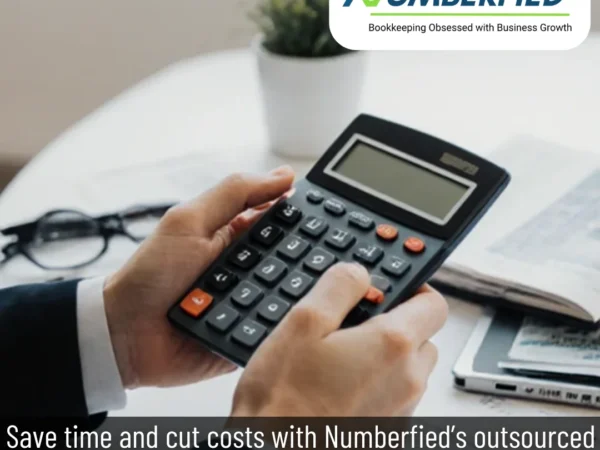 Professional reviewing numbers on calculator for outsourced bookkeeping and accounting services.