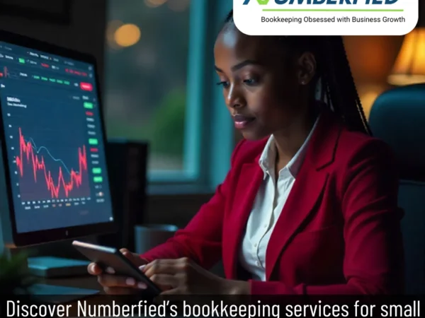 Female accountant using phone at desk, charts on desktop, delivering Bookkeeping Services for Small Business.
