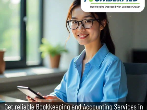 Accounting professional smiling while reviewing organized books powered by bookkeeping services for accounting firms.