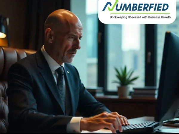 Business owner reviewing financial reports on laptop, analyzing the cost of bookkeeping services for small business.